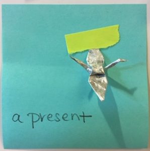 a present [with a foil origami crane attached]