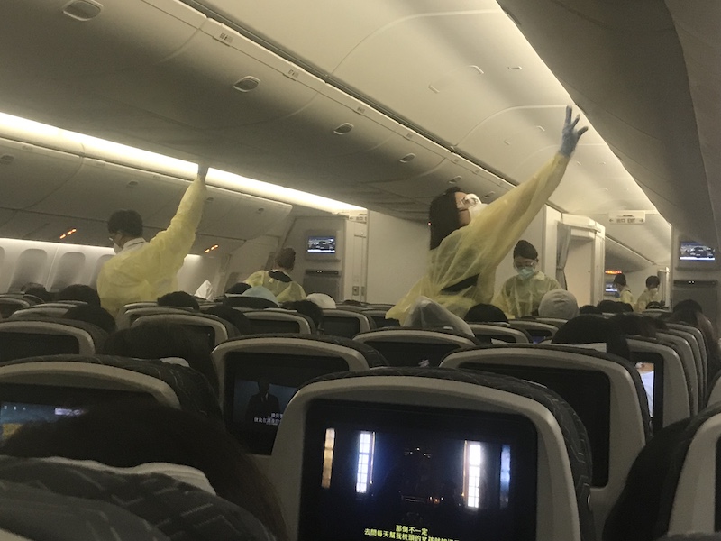 Flight attendants on international flight dressed in ppe for coronavirus
