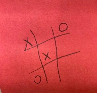 [tic tac toe board with x in the top left corner, an o in the top right corner, an x in the center, and an o in the bottom left corner]