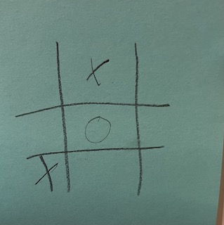[tic tac toe game with an "o" in the middle slot of the middle row, a "x" in the top middle row, and a "x" in the bottom left row.]