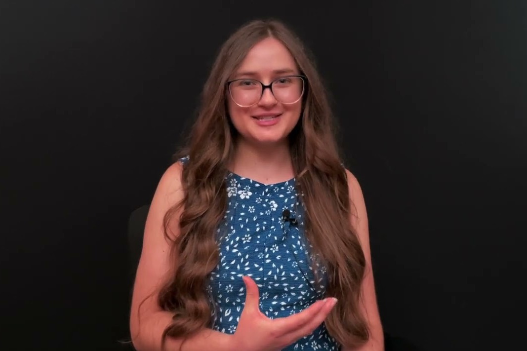 Digital Scholarship Specialist Ashlyn Stewart standing in front of a black background