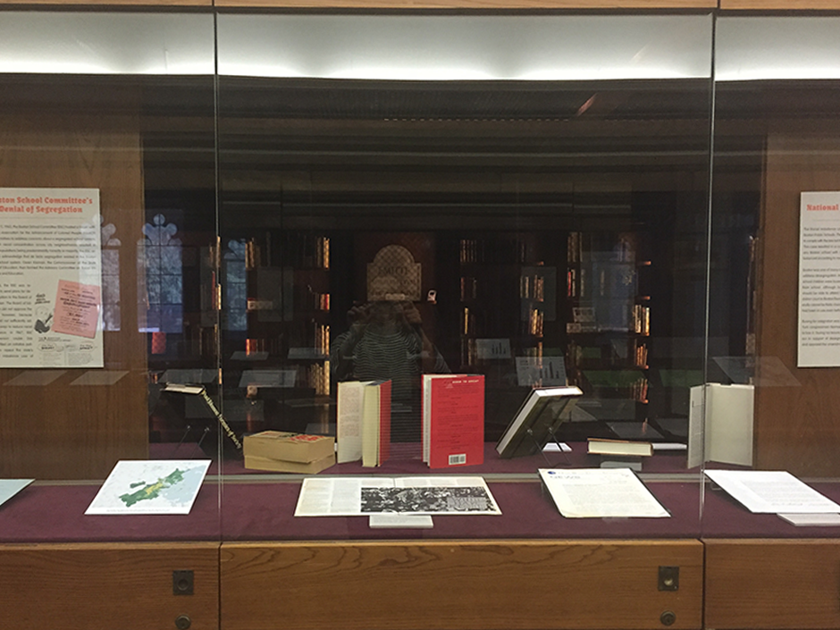 Materials for the exhibit laying in a display case in the Burns Library