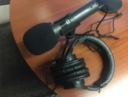close-up photo of microphone and headphones in the digital studio podcast room