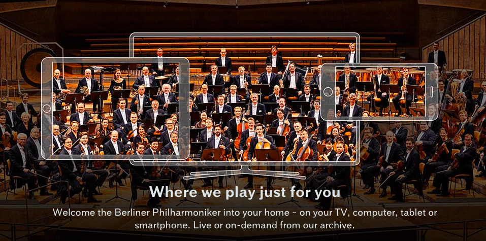 Berliner Philharmoniker home-page, showing the entire formally-clad Philharmoniker superimposed on semi-transparent outlines of a smartphone, a notebook pad, and a computer screen