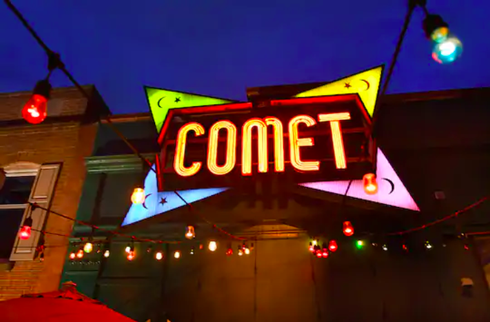 The bright yellow, blue, pink, and green "Comet" neon sign at the Comet Ping Pong restaurant on Connecticut Avenue NW in Washington in April 2020.