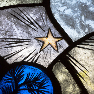 Stained glass panels: black lines emanating from a yellow star on a light lavender panel, surrounded by panels of light blue, yellow, and dark blue.