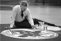 William Flynn painting Boston College logo on floor