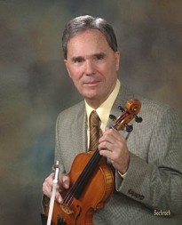 Photo of Séamus Connolly holding a violin